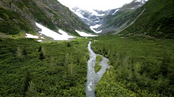 Alaska Aerial view of green valley with river and small patches of snow