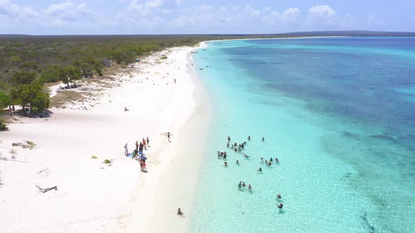 Tourists enjoy crystal clear turquoise waters of Bahia de Las Aguilas