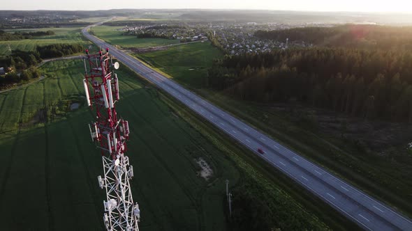 Mobile communication tower near a road in a picturesque countryside.