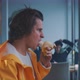 Young man takes a bit from a banana and stands up - VideoHive Item for Sale