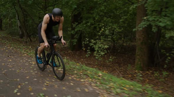 Triathlete Rides a Bike Pro Cyclist Rides on a Forest Road Preparation for Competitions and