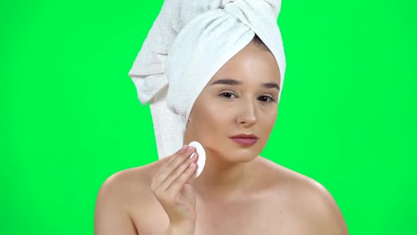 Woman in White Towel on Her Head Using Cotton Pad, Cleans Her Face Isolated on Green Screen. Close