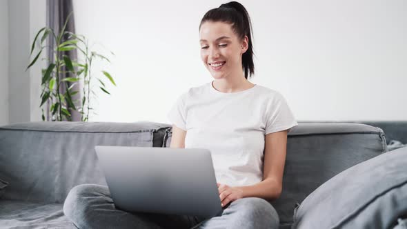 A pleased woman using her laptop