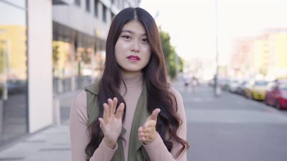 Young Asian Woman Applauds To Camera Smile Street Urban Area