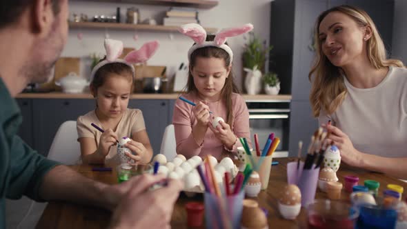 Caucasian family of four people chatting and decorating easter eggs at home. Shot with RED helium ca