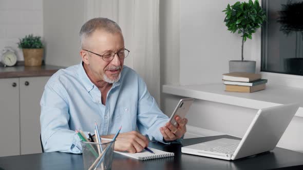 A Happy Elderly Man is Talking on a Mobile Phone