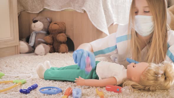 Beautiful Little Girl Playing Doctors with Doll at Home