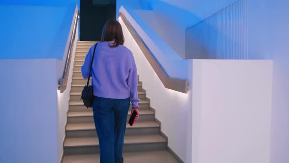 A Young Woman Walks Up the Stairs