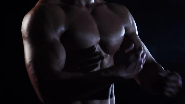 Bodybuilder Demonstrates His Body, Strength and Endurance, Black Smoke Background, Slow Motion