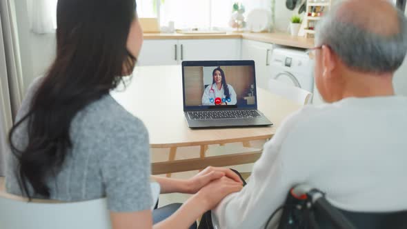 Asian senior male and daughter using computer laptop video call with doctor in living room.