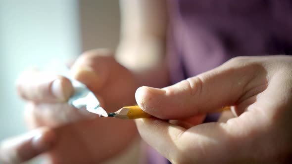 Marco Picture of Hand Sharpening Blunt Pencil with Art Knife and Cutting Mat on Background