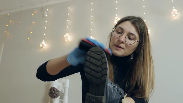 A Beautiful Young Woman Brushes Her Shoes Before Going to Work