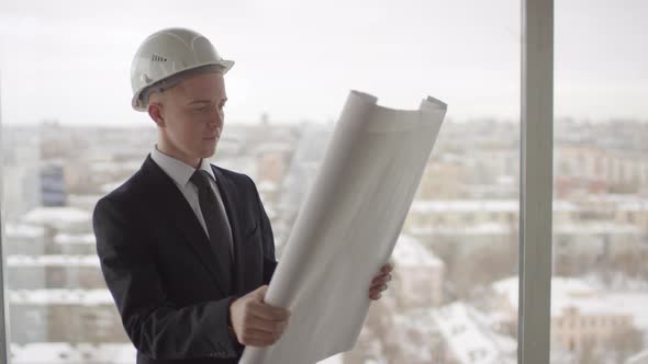 Male Site Engineer in Suit Looking at Blueprint