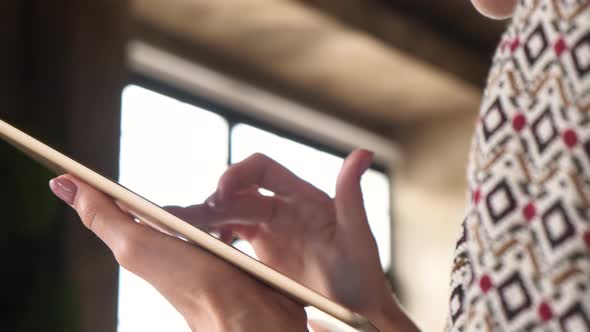 Woman hand using touchscreen display of interactive floor standing tablet - close up view