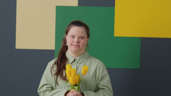 Portrait of Cheerful Girl with Down Syndrome Holding Tulips