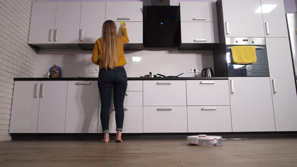 Woman Busy in Kitchen While As Cleaner Works