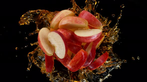 Super Slow Motion Shot of Rotating Exploded Red Apple Cuts and Splashing Juice on Black at 1000Fps alt