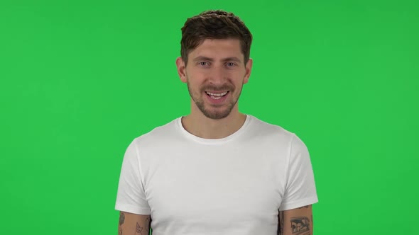 Portrait of Confident Guy Is Smiling Broadly and Winking. Green Screen