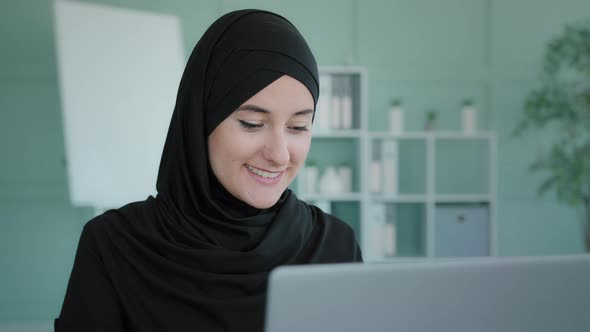 Smiling Islamic Arabian Businesswoman Working on Laptop Studying with Computer at Home Office