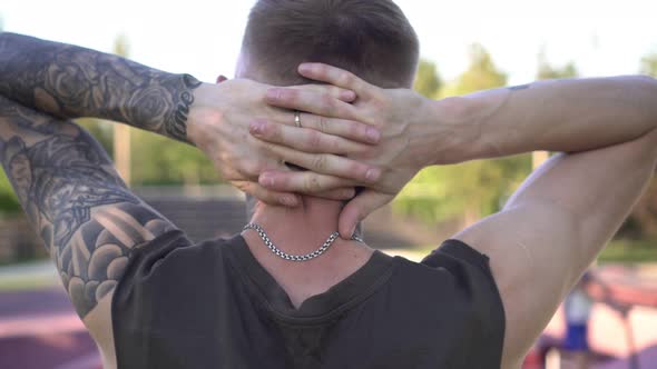 Young Man with Tattooed Arm Outdoors