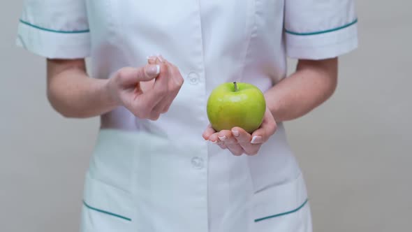 Nutritionist Doctor Healthy Lifestyle Concept - Holding Green Apple and Medicine or Vitamin Pills