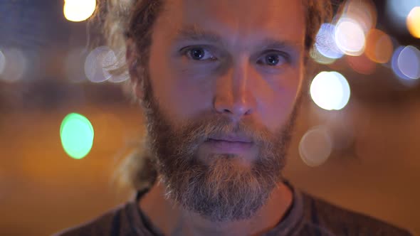 Portrait of a Handsome Bearded Long-haired Young Man Pensive Thinking Looking Straight To the Camera