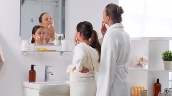 Mother and Daughter with Cotton Pads Cleaning Skin