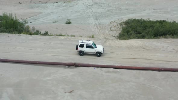 Aerial View of a Car Driving on Sand