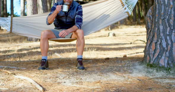 Man Having Coffee While Relaxing in A Hammock