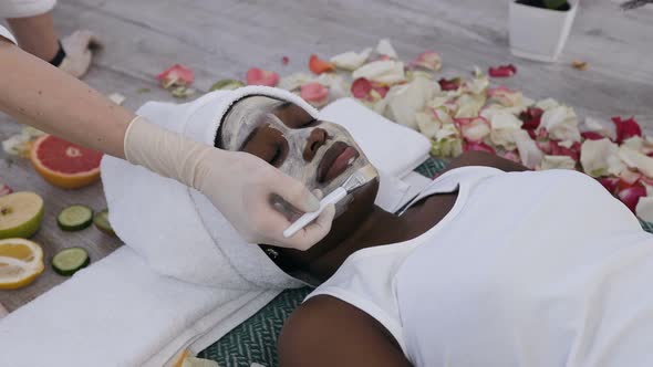 African Woman Getting Facials Care with Help Beautician in Beauty Salon