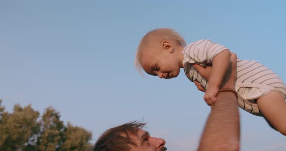 Cute Little Kid and Father Man Having Fun Together Tossing Up Throwing Son