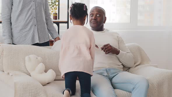 African Little Schoolgirl Child Girl Talking with Elderly Man Grandfather Mature Father Sitting on