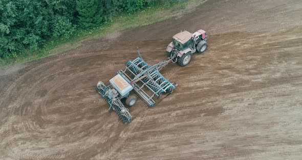 Countryside and Agriculture Grain Sowing Farm Tractors Plow the Earth in Field View From Height