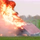 A red car explodes in an open field. The car is on fire. - VideoHive Item for Sale