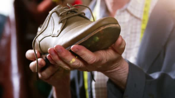 Shoemaker examining a shoe