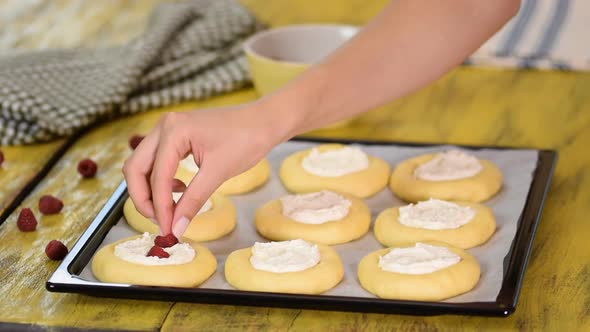 Baking homemade open patties with cottage cheese and raspberries