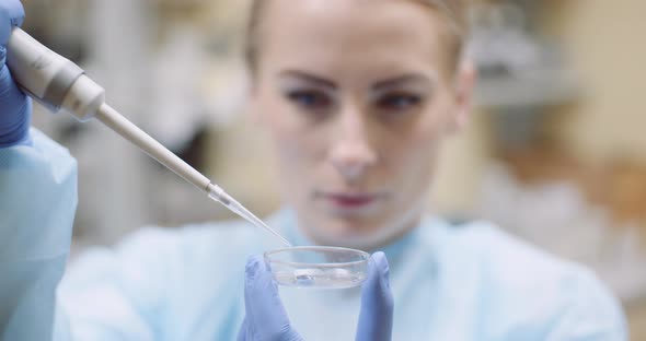 Scientist Using Pipette During Experiment at Laboratory