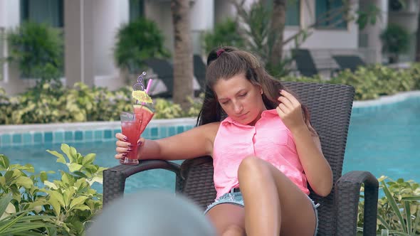 Pretty Lady Relaxes on Lounge Chair Near Hotel Swimming Pool