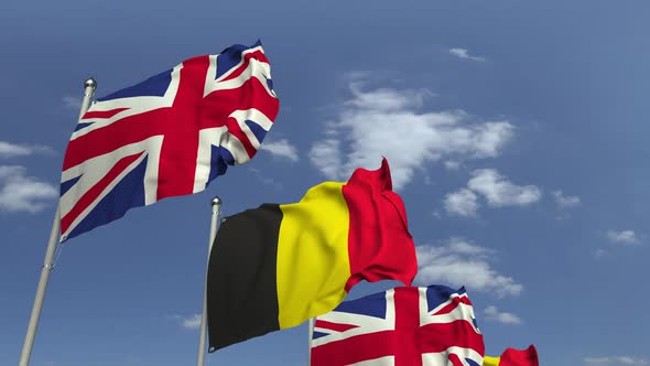 Flags of Belgium and the United Kingdom Against Blue Sky