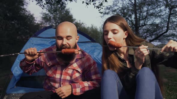 Picnic in the Woods. Tourists Eat Fried Grilled Sausages