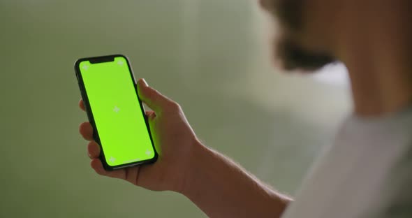 Young Adult Man Using Smartphone with Green Screen During Fitness Sport Workout