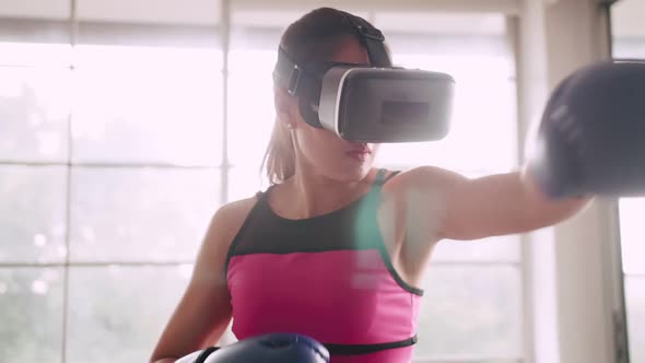 Young Asian woman wearing virtual reality glasses while working out at home.