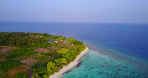 Wide aerial island view of a white sand paradise beach and aqua turquoise water background 