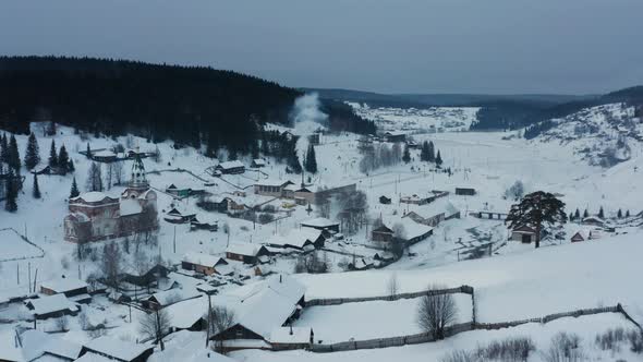 Aerial View of Smoke Coming From Stoves in Wooden Houses in the Village in Winter