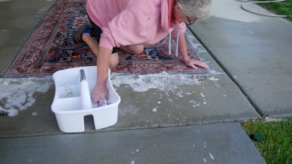 Hand scrubbing an oriental or Persian carpet with soap and water