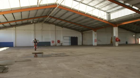 BMX rider in an empty warehouse