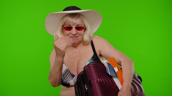 Senior Woman Tourist in Swimsuit with Luggage Passport Tickets Asking to Follow Join on Chroma Key