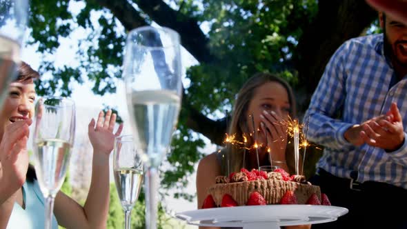 Friends celebrating womans birthday at outdoor restaurant