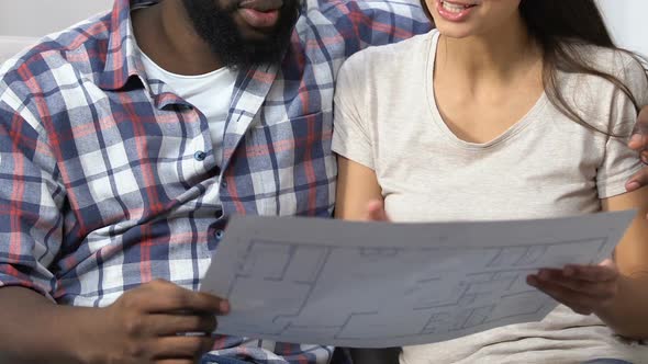 Multi-Ethnic Couple Looking at Project and Planning Design of New Apartment