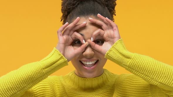 Playful Female Student Showing Binocular Gesture Front of Eyes, Having Fun